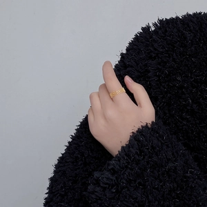 Detailed view of an 18K gold plated lace hollow ring worn on a finger for a chic look
