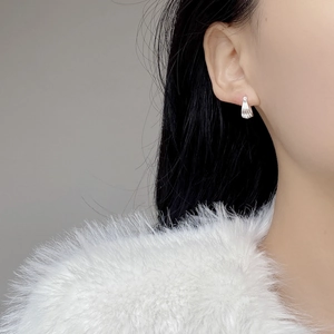 Minimalist S925 sterling silver shell-textured hoop earrings worn by a model