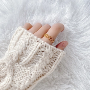 Elegant gold hollow lace flower ring for women set against a cozy white knit background