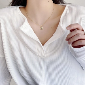 Close-up of a 925 silver gold-plated necklace with a rectangular crystal pendant on model
