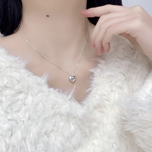 Detailed view of S925 sterling silver heart pendant on a thin link chain worn by a model