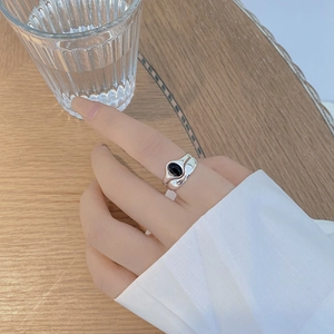 Detailed shot of S925 sterling silver ring with oval black agate on a wooden table
