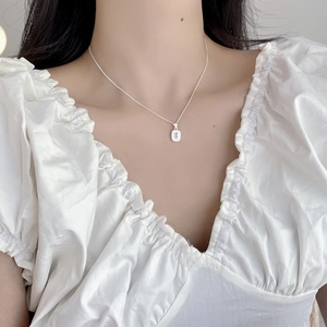 Close-up of geometric emerald cut clear zircon pendant on sterling silver chain