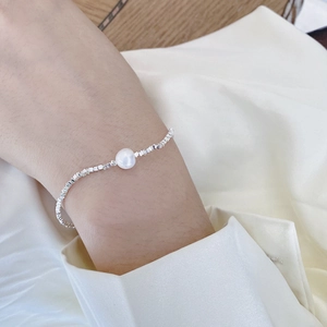 Detail of S925 silver beaded bracelet with a natural baroque pearl on a woman's wrist