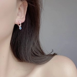 Close-up of S925 sterling silver hoop earrings with a polished round blue turquoise pendant
