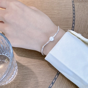 Vintage S925 sterling silver geometric bracelet with a baroque pearl on a wooden background