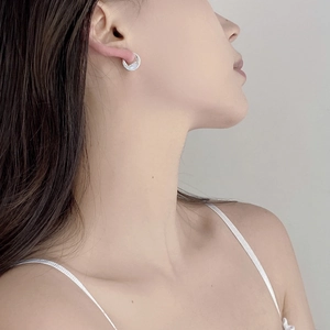 Close-up of a model wearing a minimalist silver geometric round stud earring