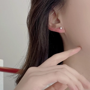Close-up of minimalist S925 sterling silver ball stud earring on a female ear