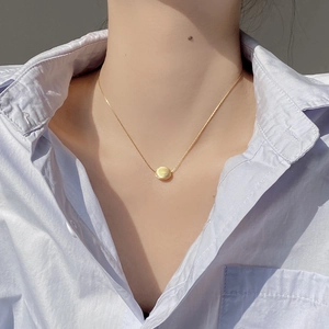 Minimalist S925 sterling silver golden brushed bean pendant necklace on a model