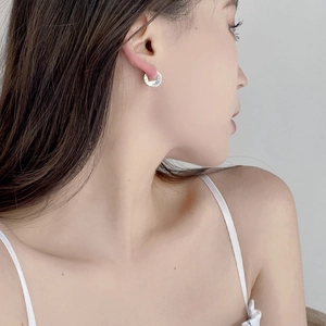 Minimalist S925 sterling silver hoop earrings with circular pendants worn by a model