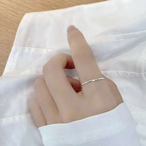 Detail of adjustable S925 sterling silver beaded chain ring worn on a finger