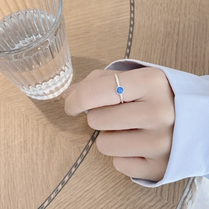 Detailed view of S925 sterling silver ring with blue gemstone on finger