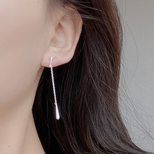 Macro detail of elegant long S925 sterling silver tassel earrings with waterdrop pendant