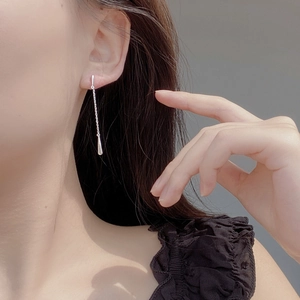 Close-up of elegant S925 sterling silver drop tassel earrings worn by a model