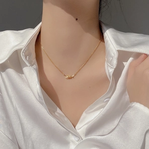 Minimalist S925 sterling silver spring necklace in gold worn over a white satin shirt