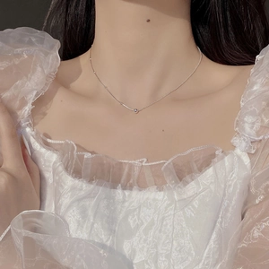 Detail of minimalist S925 sterling silver ball necklace worn on a female model