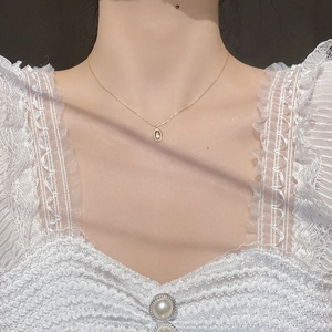 Close-up of S925 sterling silver oval coffee bean pendant necklace on woman neck