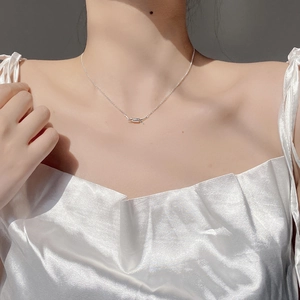 Close-up of S925 sterling silver spring knot necklace worn by model on neck