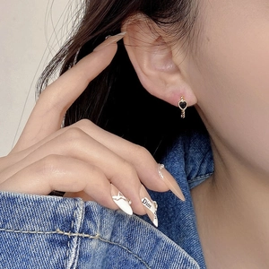 Close-up of black heart earrings with gold twisted rope texture worn by a model