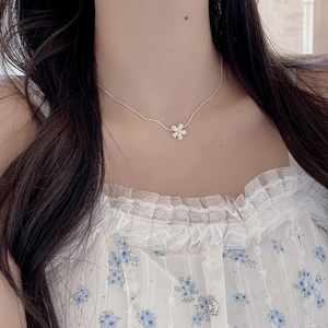 Close-up of S925 sterling silver daisy flower pendant necklace on woman's neck
