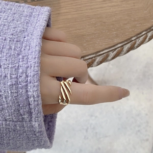 Detailed view of gold plated hollow ladder ring on hand with purple knit sweater