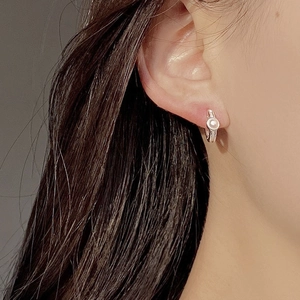 Gros plan de petite boucle d'oreille créole en argent 925 avec perle d'eau douce
