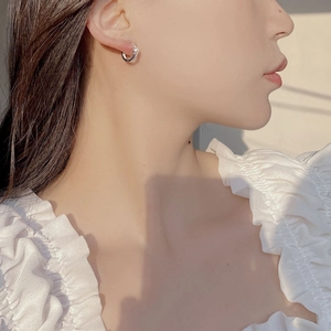 Gros plan d'une boucle d'oreille créole en argent 925 portée par un mannequin