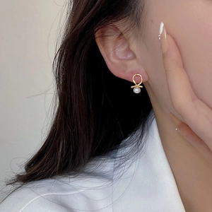 Minimalist 925 silver cross stud earrings with round white pearl on female model
