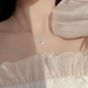 Close-up of S925 silver necklace with light blue oval pendant on model neckline