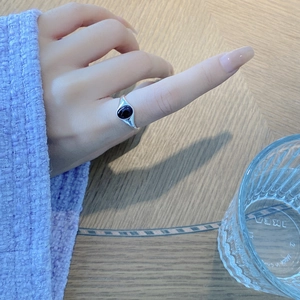 Close-up of S925 sterling silver ring featuring a dark oval onyx gemstone on female hand