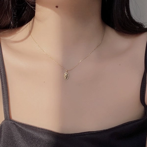 Elegant gold oval bean pendant necklace in S925 sterling silver worn on a woman's neck