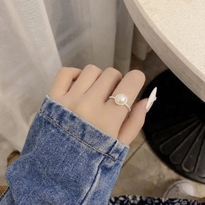 Detailed view of an adjustable 925 silver ring with a white freshwater pearl on finger