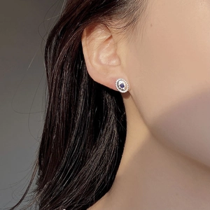 Minimalist S925 sterling silver star stud earrings with deep blue gemstone on a model