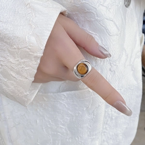 Primer plano de anillo de plata de ley 925 con piedra ojo de tigre en el dedo