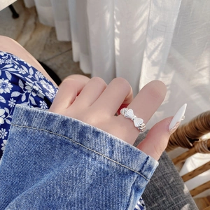 Close-up of S925 silver bow ring with vertical stripe texture on a woman's hand