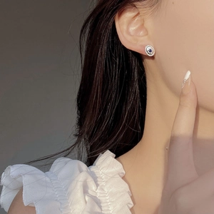 Detail of vintage oval stud earrings with deep blue gemstone on female ear
