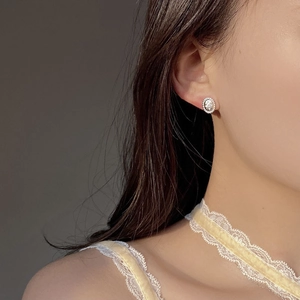Close-up of vintage oval silver stud earrings with center stone on female ear