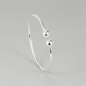 Minimalist 925 sterling silver cuff bracelet with double beads on a neutral background
