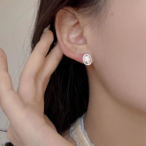 Macro shot of S925 silver oval stud earring with star relief and beaded edge detail