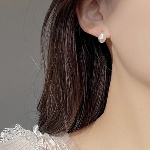 Minimalist S925 silver bean earrings with a matte brushed finish on female model