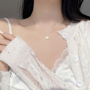 Elegant S925 sterling silver necklace with white shell pendant worn by a model