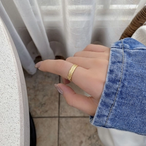 Bague double couche en argent doré sur l'index avec une veste en denim décontractée