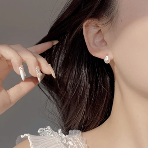 Macro shot of 925 sterling silver earring featuring irregular faceted white pearl texture