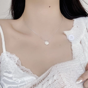 Close-up of minimalist S925 sterling silver necklace with white pearl shell pendant