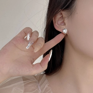 Gros plan de boucles d'oreilles en argent S925 ondulé avec texture coquille sur modèle