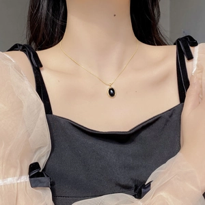 925 silver oval black onyx pendant necklace with gold chain worn on the neck