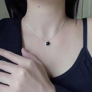 Close-up of S925 sterling silver necklace featuring an oval black onyx gemstone pendant