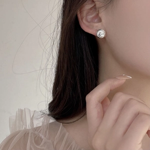 Boucles d'oreilles boules ondulées en argent S925 portées par un mannequin poli