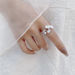 Detail of matte silver S925 sterling silver wavy ring with elegant textured ripples