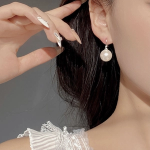 Elegant 10mm round pearl hoop earrings in S925 sterling silver worn by a model
